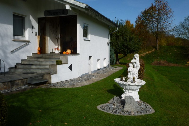 Eingang des Hauses Wiesengrund mit Steinfigur im Garten